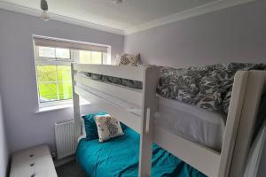 a small bedroom with a bunk bed and a window at Haven Cottage - adjacent to beach and promenade in Walmer