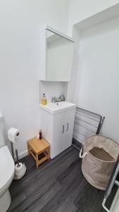ein Badezimmer mit einem WC, einem Waschbecken und einem Spiegel in der Unterkunft Haven Cottage - adjacent to beach and promenade in Walmer