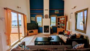 sala de estar con sofá y TV en Skiathos Seaview Villa with Pool, en Punta