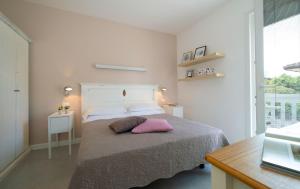 een slaapkamer met een bed met een roze kussen erop bij Nice Hotel Bibione in Bibione
