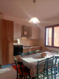 a kitchen with a table and some chairs and a kitchen with a table at Villetta singola "Lilla" in Alì Terme