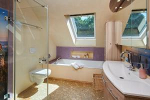 a bathroom with a tub and a toilet and a sink at Laasenhof in Struppen