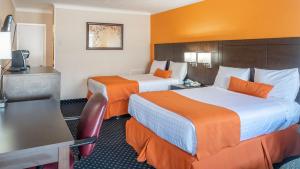 um quarto de hotel com duas camas com paredes laranja em Knights Inn North Bay em North Bay