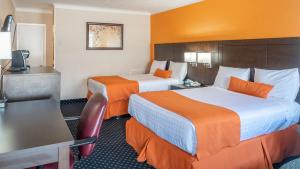 a hotel room with two beds with orange walls at Knights Inn North Bay in North Bay