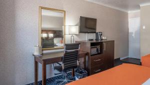 a hotel room with a desk and a mirror at Knights Inn North Bay in North Bay
