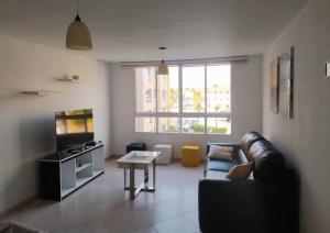 El Morro de BarcelonaにあるConfortable apartamento en Marina del Rey Lecheriaのリビングルーム(ソファ、テーブル付)