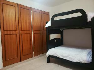 1 Schlafzimmer mit 2 Etagenbetten und Holzschränken in der Unterkunft Confortable apartamento en Marina del Rey Lecheria in El Morro de Barcelona
