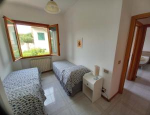 卡斯蒂利翁切洛的住宿－Appartamento Castiglioncello 600 mt dal mare，一间卧室设有两张床和窗户。