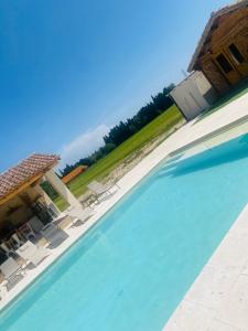 una gran piscina con sillas y una casa en Évasion romantique, en Arles
