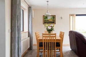 uma mesa de jantar com cadeiras e um vaso de flores em Honeysuckle Cottage em Renvyle