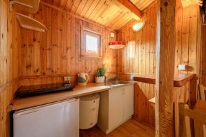 a kitchen in a wooden cabin with a sink and a counter at Domki AGA nad morzem in Bobolin