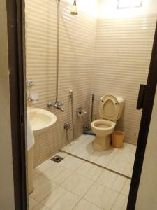 a bathroom with a shower and a toilet and a sink at Hotel Inn PECHS in Karachi