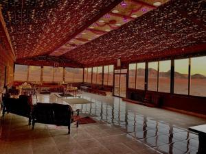 a large room with tables and chairs and windows at Salameh's Bedouin Camp in Wadi Rum