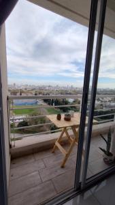 d'un balcon avec une table et une vue sur la ville. dans l'établissement Departamento amoblado alquiler temporario, à Río Cuarto