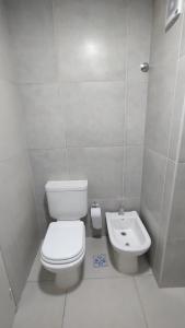 La salle de bains blanche est pourvue de toilettes et d'un lavabo. dans l'établissement Departamento amoblado alquiler temporario, à Río Cuarto