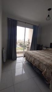 - une chambre avec un lit et une grande fenêtre dans l'établissement Departamento amoblado alquiler temporario, à Río Cuarto