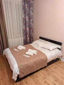 a bedroom with a bed with towels on it at Holiday House Likani in Borjomi