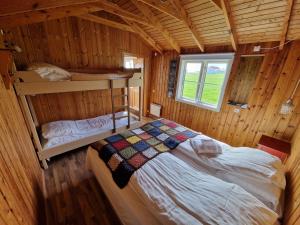 a bedroom with a bed in a wooden cabin at Berunes HI Hostel in Berunes