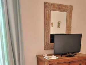 a flat screen tv sitting on a dresser in front of a mirror at Boulevard du Soleil in Bormes-les-Mimosas