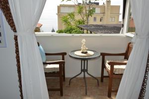 balcone con tavolo, sedie e finestra di Apartman Vasanija a Opatija