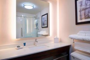 a white bathroom with a sink and a mirror at Four Points by Sheraton Detroit Novi in Novi