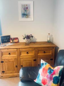 a wooden cabinet in a living room with a pillow at Waverley Court in Fort William