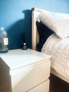 a bedroom with a white bed and a bottle on a night stand at Waverley Court in Fort William