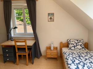 a bedroom with a desk and a bed and a window at Chalupa u Pavelků 