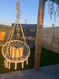 a rattan chair hanging from a porch at The Garden Pod with Private Hot Tub in Ballymagan