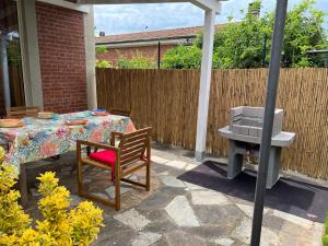 a patio with a table and a grill in a backyard at CivicoNove in Piombino