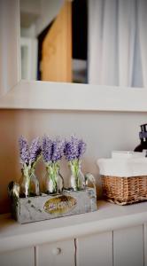 a shelf with purple flowers in vases on it at Unique & Stylish Town House, central Cheltenham in Cheltenham