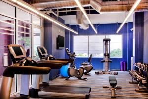 a gym with treadmills and exercise equipment in a room at Aloft Arundel Mills BWI Airport in Hanover