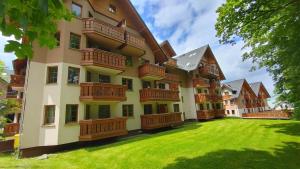 ein großes Gebäude mit Holzbalkonen und einem Hof in der Unterkunft Apartament Mięta in Karpacz