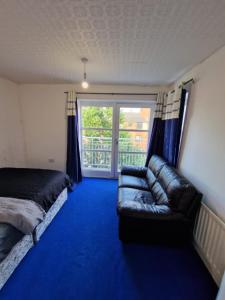 a living room with a couch and a large window at Room in a shared Flat in London