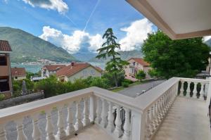 a balcony with a view of a town and mountains at Nikola - Two Bedroom Ap. with SeaView in Kotor