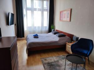 a small bedroom with a bed and a blue chair at Large and cozy apartment in the center of Karlovy Vary in Karlovy Vary