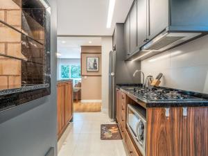 a kitchen with a sink and a stove at Delle Alpi 310B - Ao lado da roda-gigante in Canela