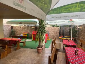 a restaurant with tables and chairs and a play area at Stamatovi Family Hotel in Pomorie