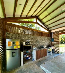 uma cozinha com um frigorífico e um fogão em Sunset Hut Hostel em Omoa
