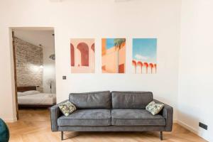 sala de estar con sofá y pinturas en la pared en Harmonie en Nimes