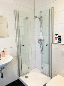 y baño con ducha y lavamanos. en Bungalow-Wohnung nahe Flughafen Hamburg en Norderstedt