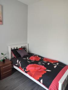 a bedroom with a bed with red flowers on it at havilahomes in Manchester
