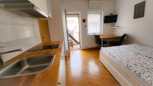 een keuken met een wastafel en een bed in een kamer bij Apartments Old Town in Ljubljana