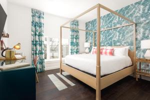 a bedroom with a canopy bed with blue and white curtains at Lily Hall-A Boutique Hotel in Pensacola