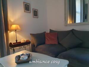 sala de estar con sofá y mesa en L appart d en face en Sarlat-la-Canéda