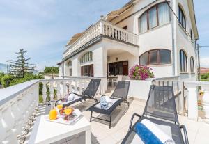 a patio with chairs and tables on a balcony at Tinel Apartment Sukosan in Sukošan