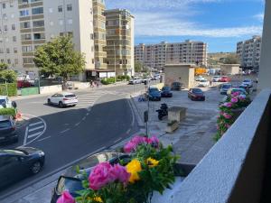 a balcony with flowers on a city street with buildings at Casa vacanze “Dolce sosta” in Quartu SantʼElena