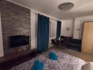 sala de estar con cama y TV de pantalla plana en Studio with terrace Tatragolf mountain resort H104, en Veľká Lomnica