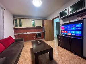 uma sala de estar com um sofá e uma televisão de ecrã plano em Golem Getaway Apartment em Golem