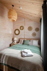 a bedroom with a bed in a wooden wall at Forrest Guest House in Ķesterciems